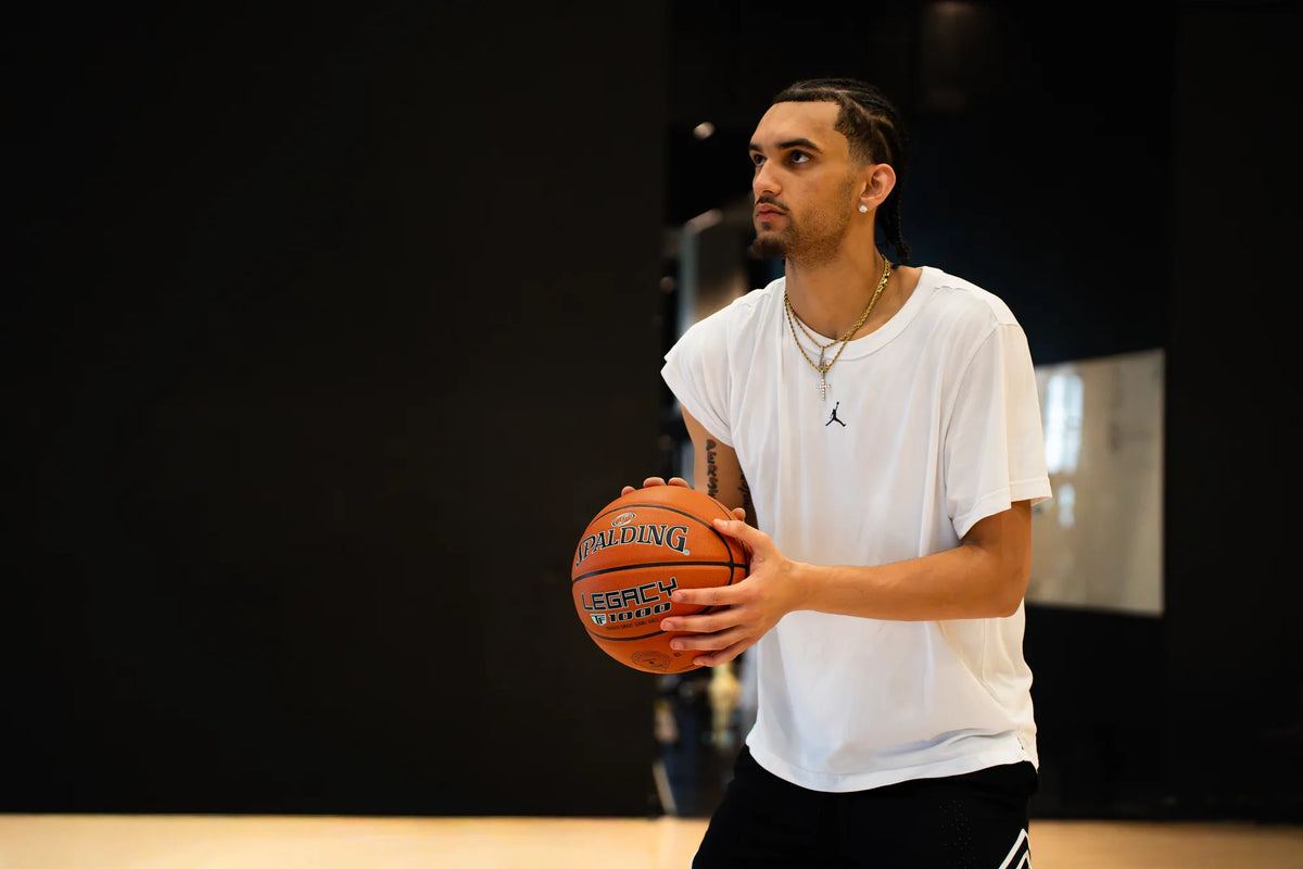 Player holding a Spalding Legacy TF1000 basketball in an indoor gym